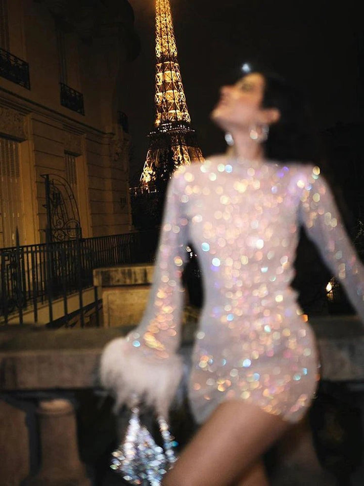 Close-up of sequin mini dress with detailed feather cuffs. Highlighting the luxurious texture & sparkle.