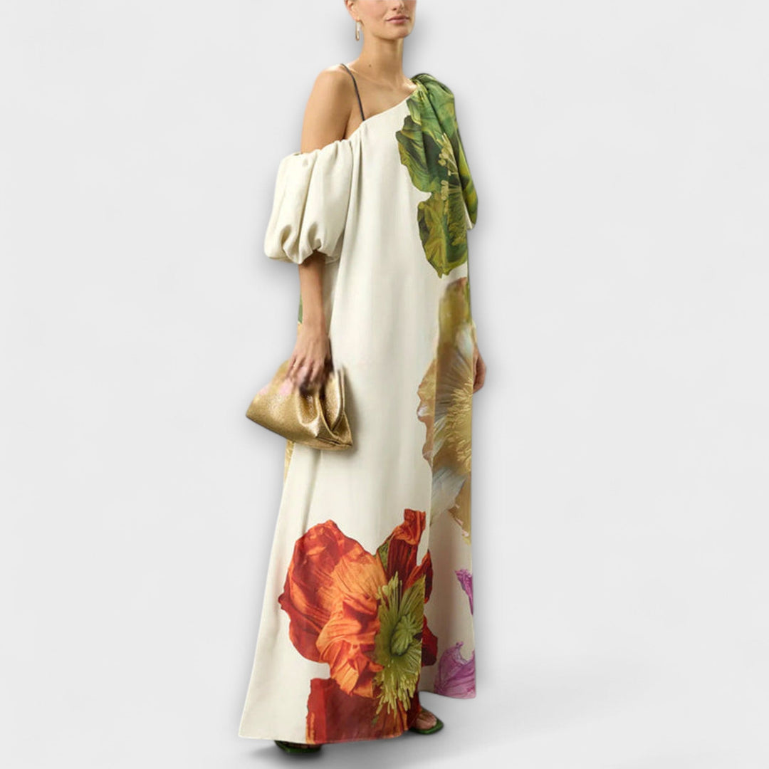 Close-up of a women's floral maxi dress showcasing the unique asymmetrical neckline, puff sleeve, & vibrant print.