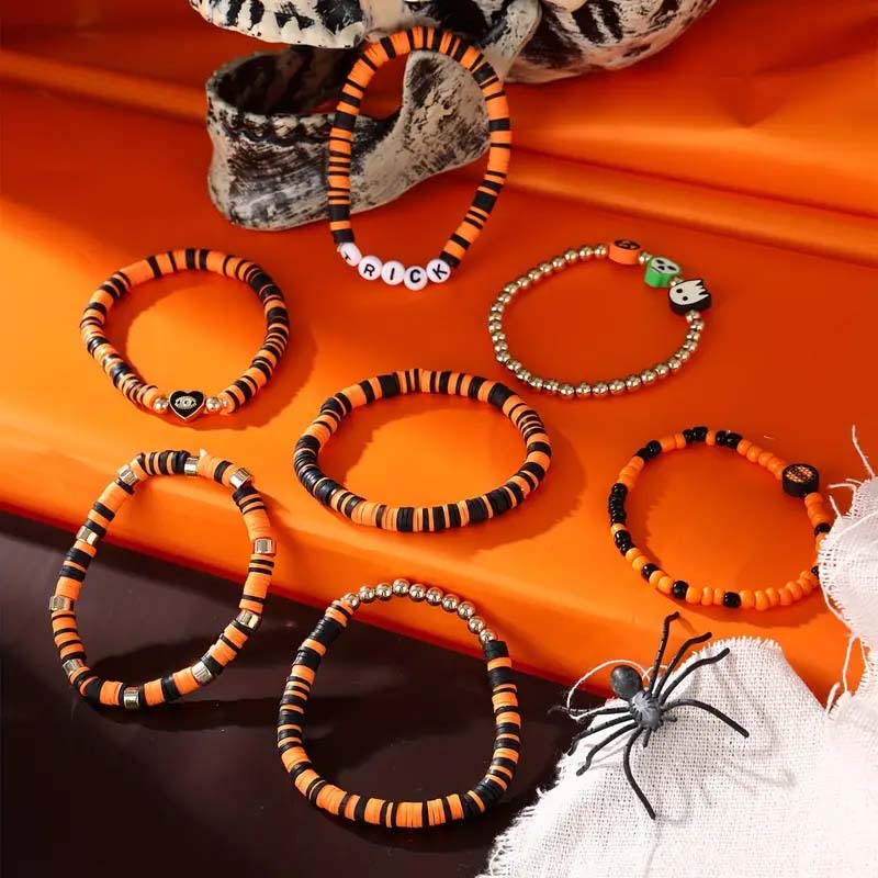 Close-up of a festive Halloween bracelet featuring white ghost and orange pumpkin beads.