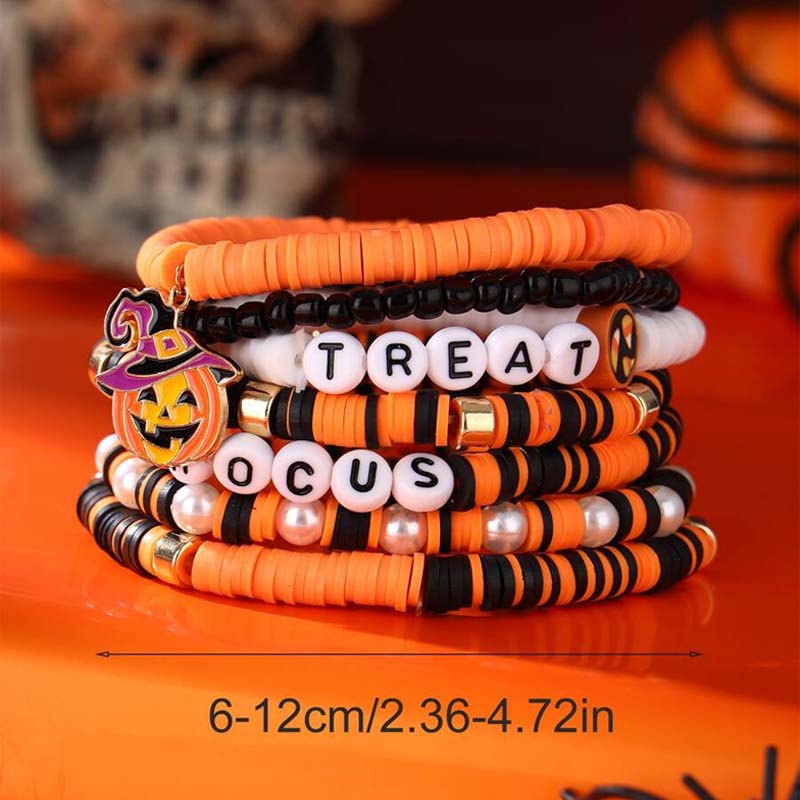 Hand modeling the unisex Halloween ghost and pumpkin beaded bracelet set.