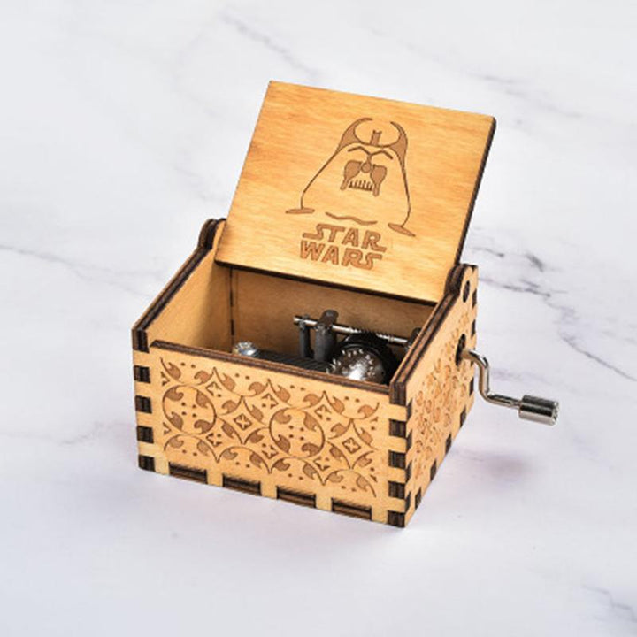 Detailed view of a hand-cranked wooden music box, emphasizing its decorative and functional artistry