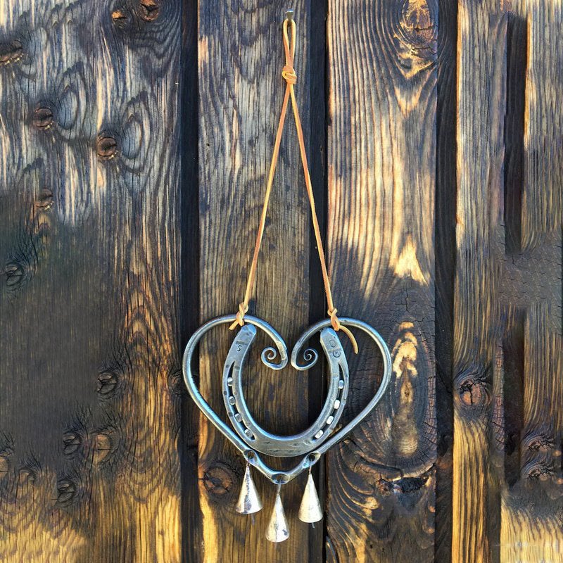 Heart-shaped metal wind chime, intricate design, for romantic garden decor and outdoor spaces.