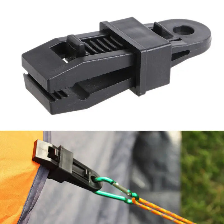 Multiple heavy-duty tarp clips attached to a green shade cloth, demonstrating their utility.