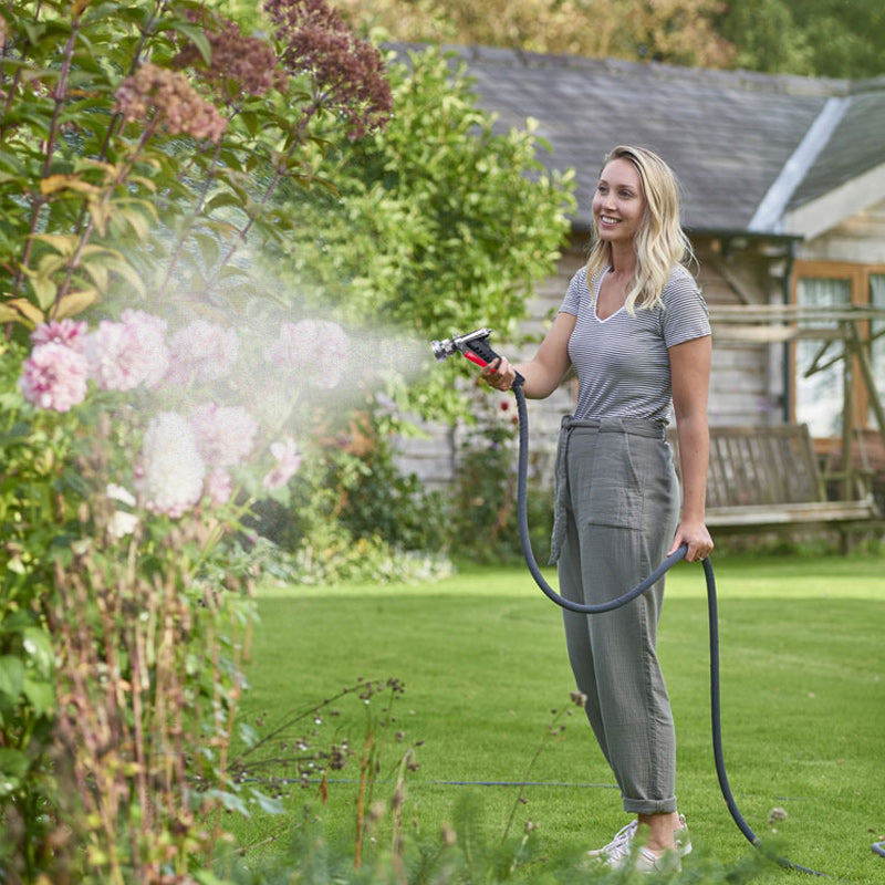 Effective outdoor cleaning with a high-pressure electric spray gun, removing dirt.