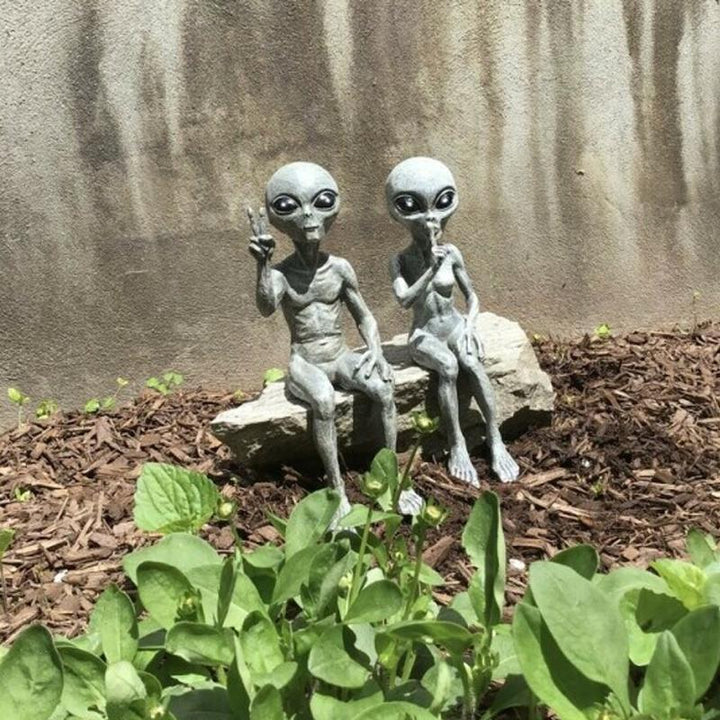 Close-up of a detailed alien garden statue with large eyes and a mischievous smile