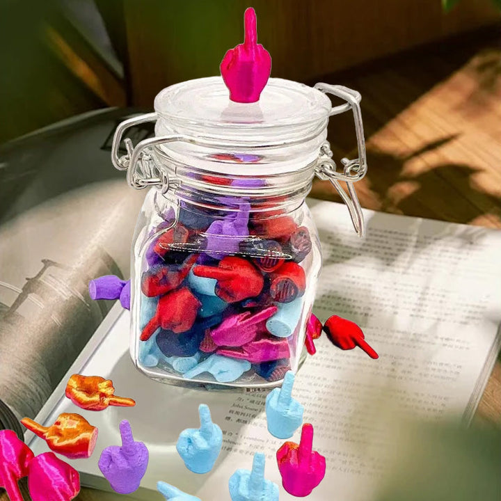Unique humorous desktop decor: Glass jar containing multiple miniature middle fingers, quirky gift idea.