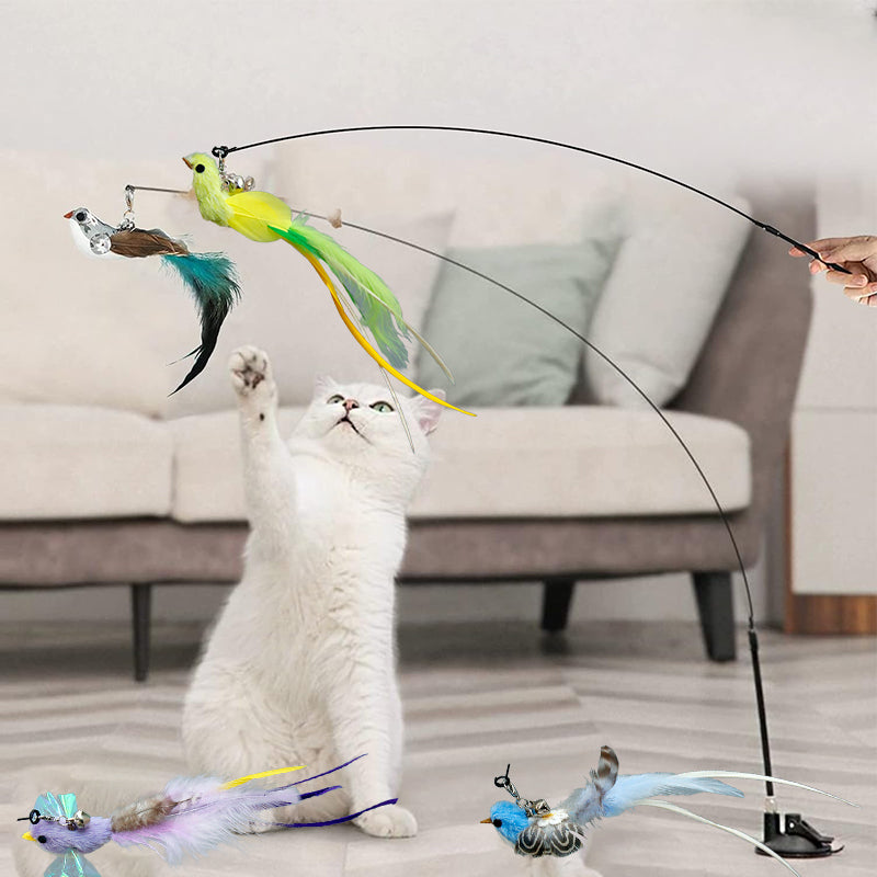 A cat playfully batting at the feathered bird design of an interactive wand toy with suction cup.