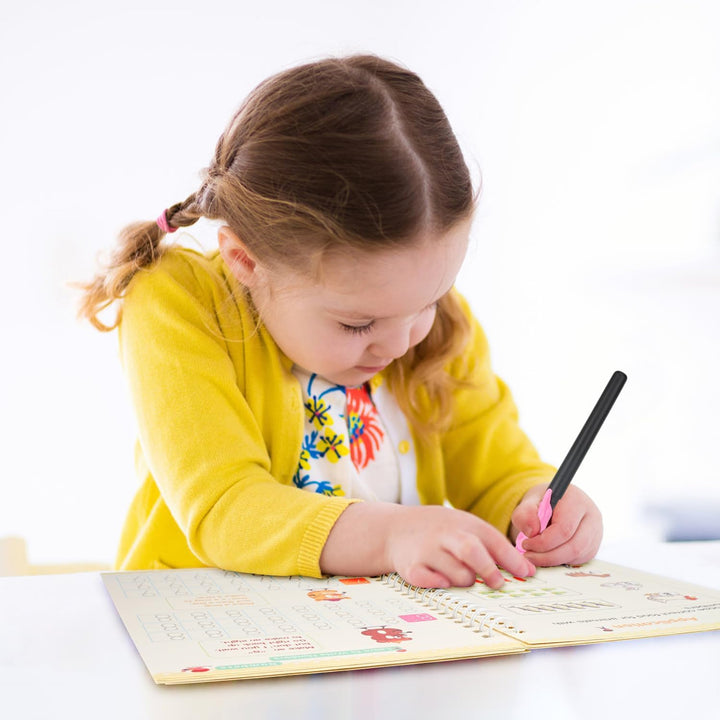 Toddler using a magic ink pen on a reusable math skills book, engaging early education tool