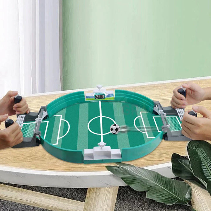 Family enjoying interactive soccer tabletop game, parents & child laughing, educational board game
