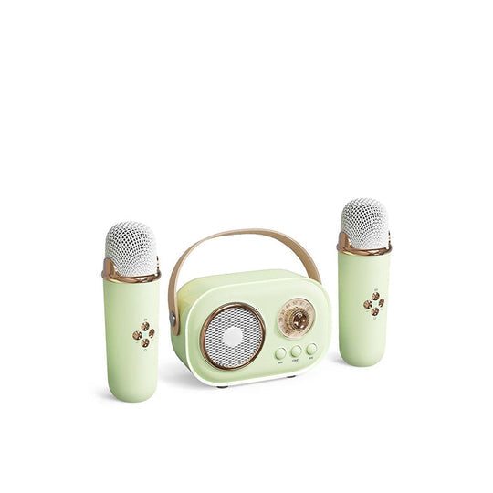 Children dancing around a portable karaoke speaker playing music, with the wireless mic in use.