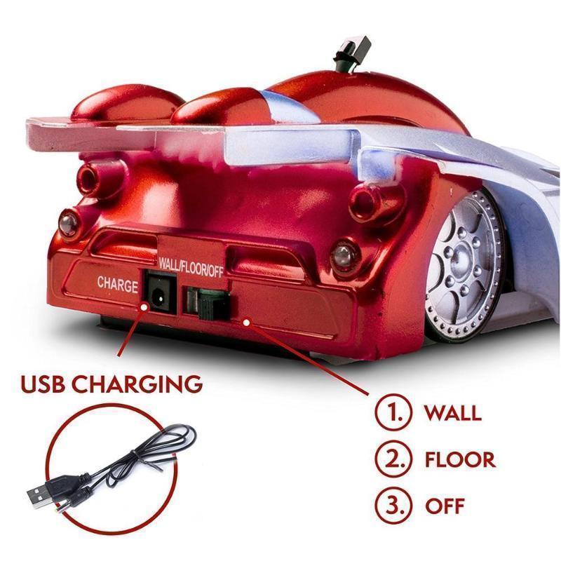 Overhead view of a child playing with a wall climbing RC car on a flat surface before it climbs, LED headlights on