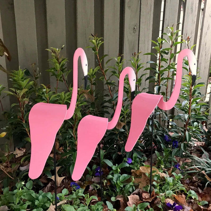 Tall kinetic flamingo wind spinner, striking profile against a blue sky, ideal garden accent