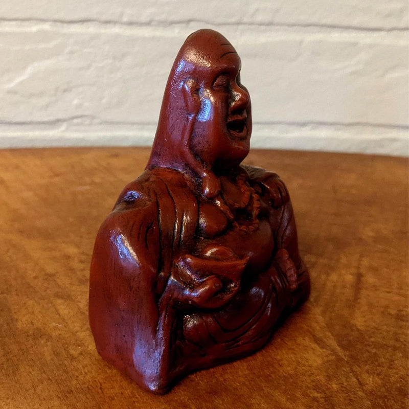 Close-up of a funny meditating Buddha sculpture, ideal desk decor and gift item