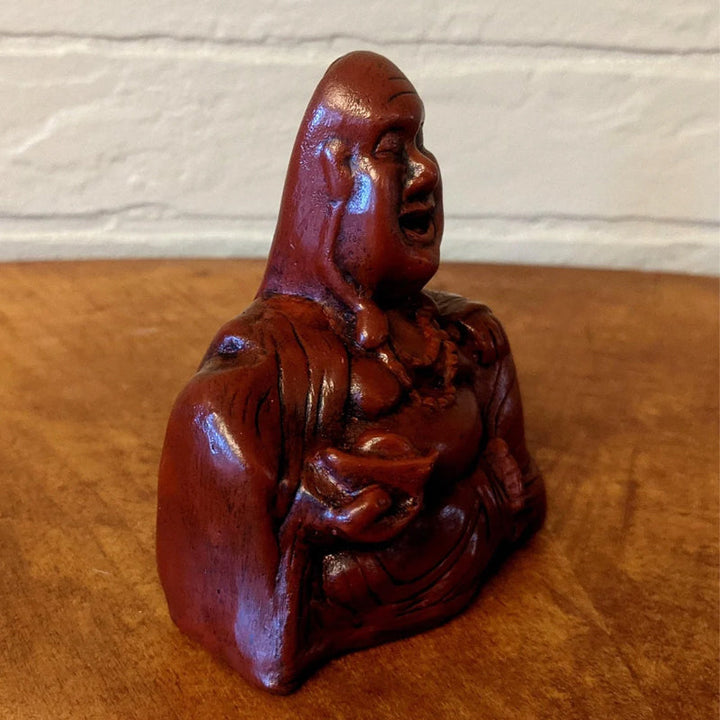 Close-up of a funny meditating Buddha sculpture, ideal desk decor and gift item