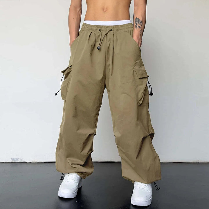 Streetwear men's parachute pants, baggy fit with cargo pockets, embodying Y2K fashion and hip hop aesthetic.