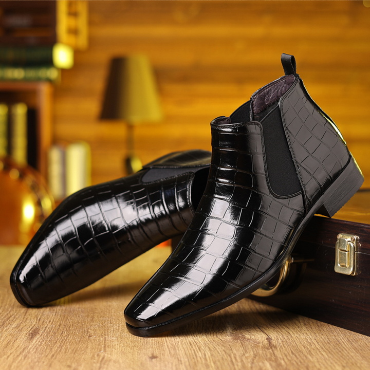Side view of stylish men's croc embossed Chelsea boots. Features elegant texture and comfortable fit.