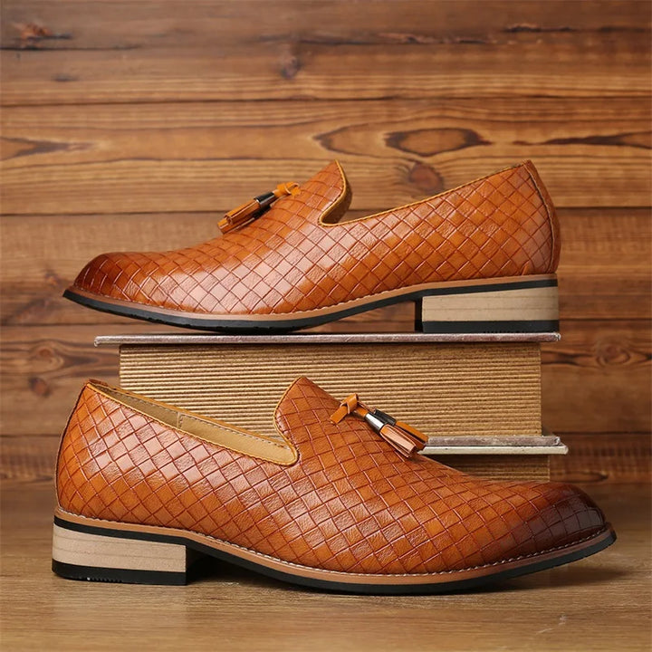 Close-up of the tassel detail on men's textured loafers, highlighting quality design