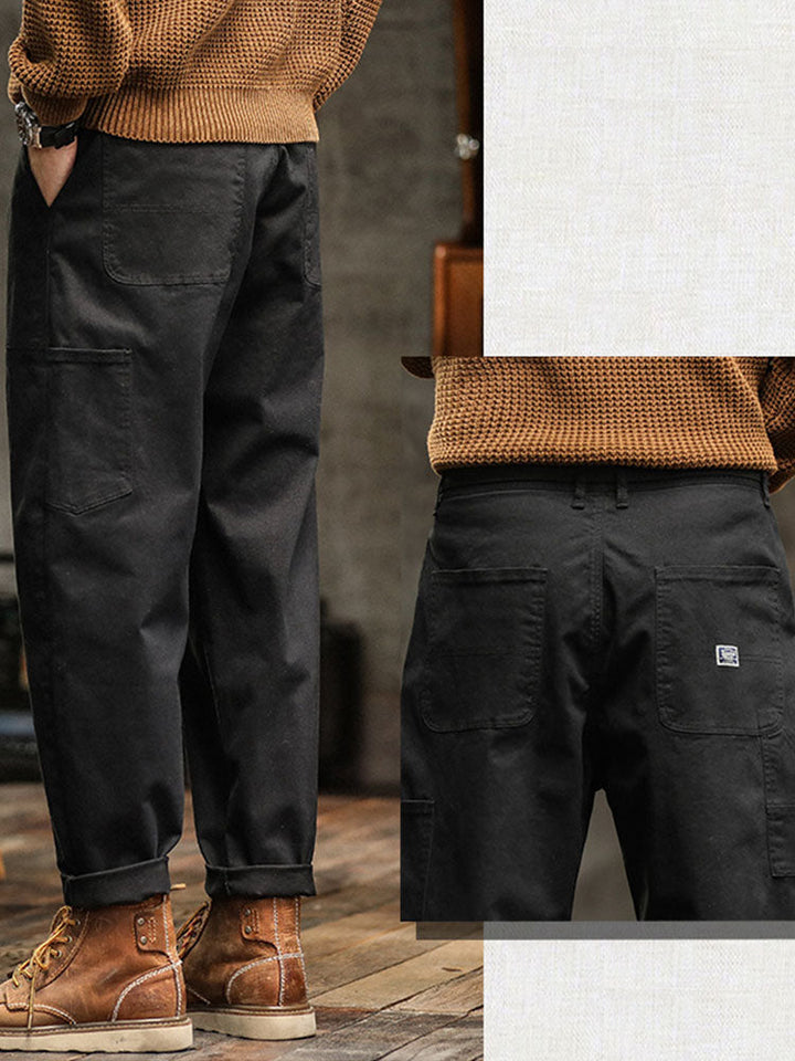 Army green men's vintage utility pants with adjustable cuffs for a rugged, casual style.