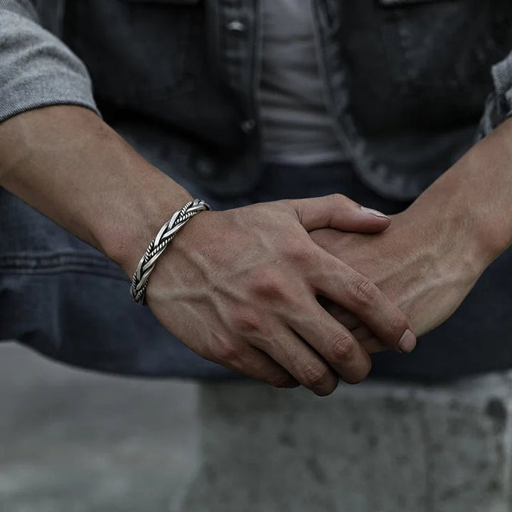 Close-up of a men's sterling silver braided cuff bracelet. Stylish open-cuff design for men's fashion.