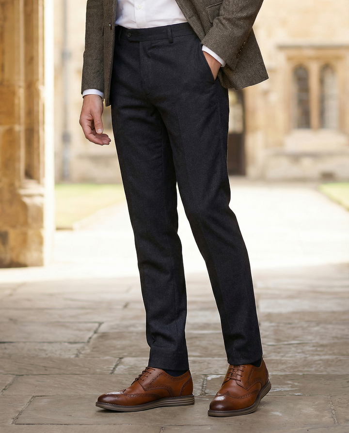 Close-up of men's detailed brown leather brogue Oxford shoes, showcasing classic perforations and lacing.