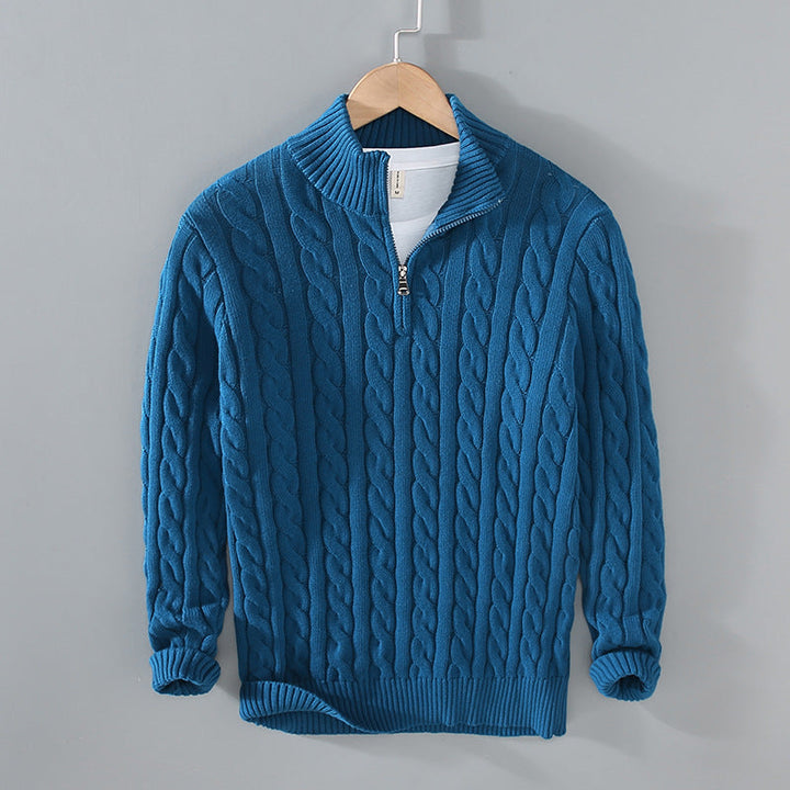 Close-up of the intricate cable knit detail and half-zip collar on a men's fashionable pullover sweater.