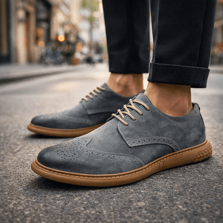 Stylish black lace-up dress shoes for men with subtle brogue details, ideal for formal & casual outfits.