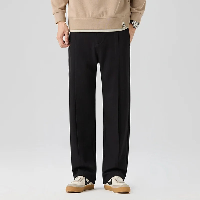 Close-up of men's elegant drape trousers, showing pleats, relaxed fit, & soft fabric for comfort.