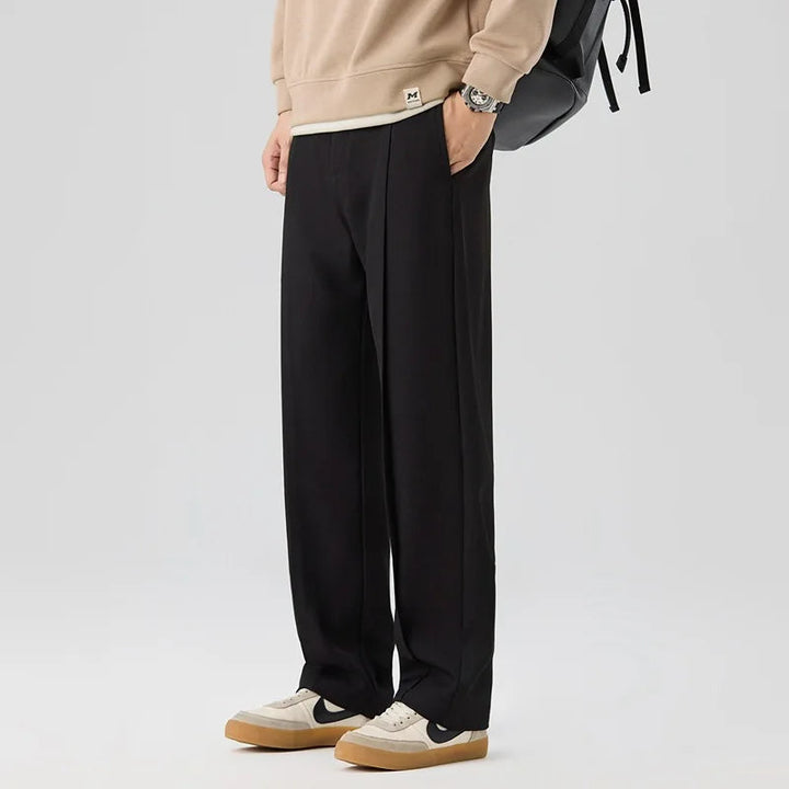 Detailed shot of luxurious fabric and elegant drape of men's comfortable pleated trousers for style.