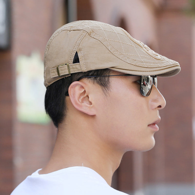A model wearing a men's embroidered cotton beret, styled for a modern classic look.