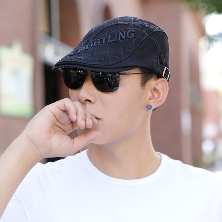 Detail shot of the embroidery on a men's cotton beret, emphasizing the craftsmanship and design.
