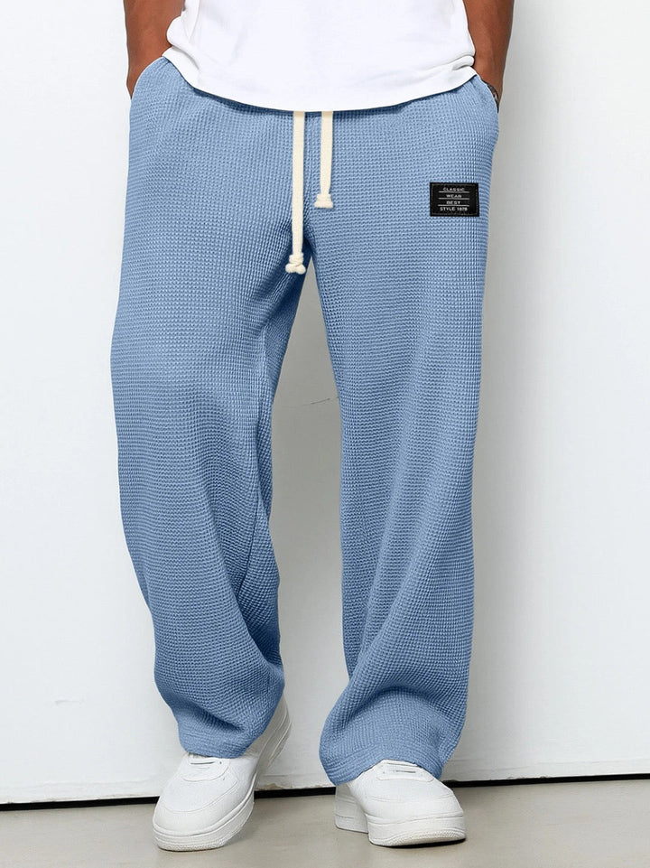 Wide leg men's casual pants with adjustable drawstring, ideal for comfort and style.