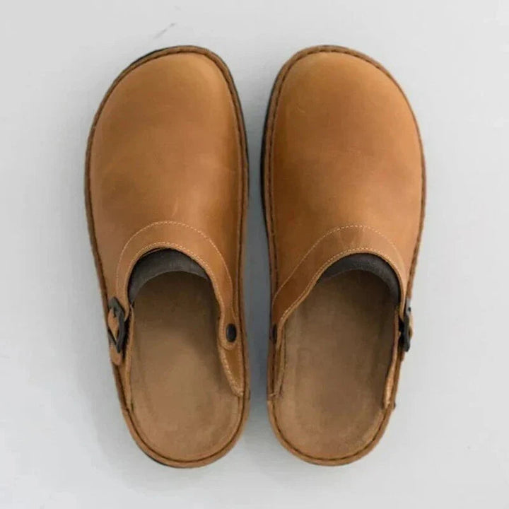 Stylish men's brown leather clogs, slip-on design for easy wear and comfort.