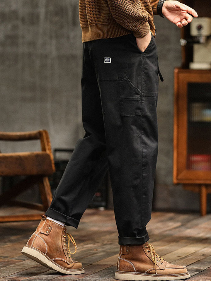 Detail of the waistband and button closure on men's relaxed fit utility pants, showcasing quality.