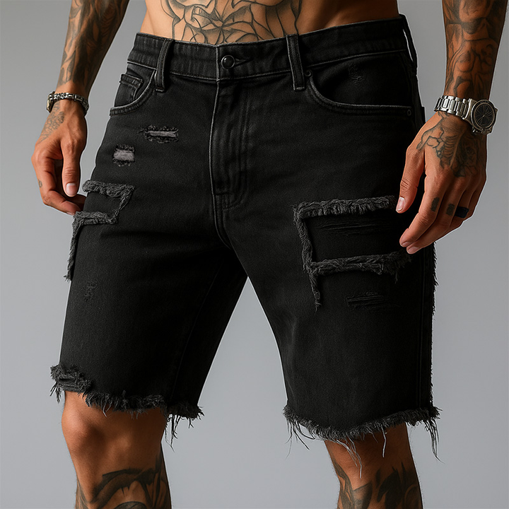 Man wearing comfortable ripped stretch denim shorts. Casual summer style with distressed details & five-pocket design.