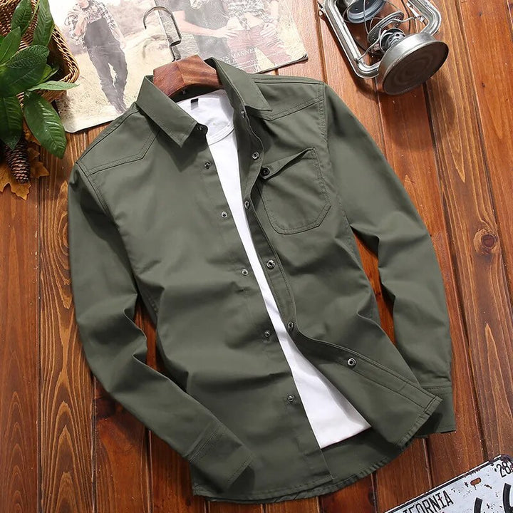 Navy blue men's button-down tactical shirt with epaulettes & practical chest pockets. Versatile outdoor fashion.
