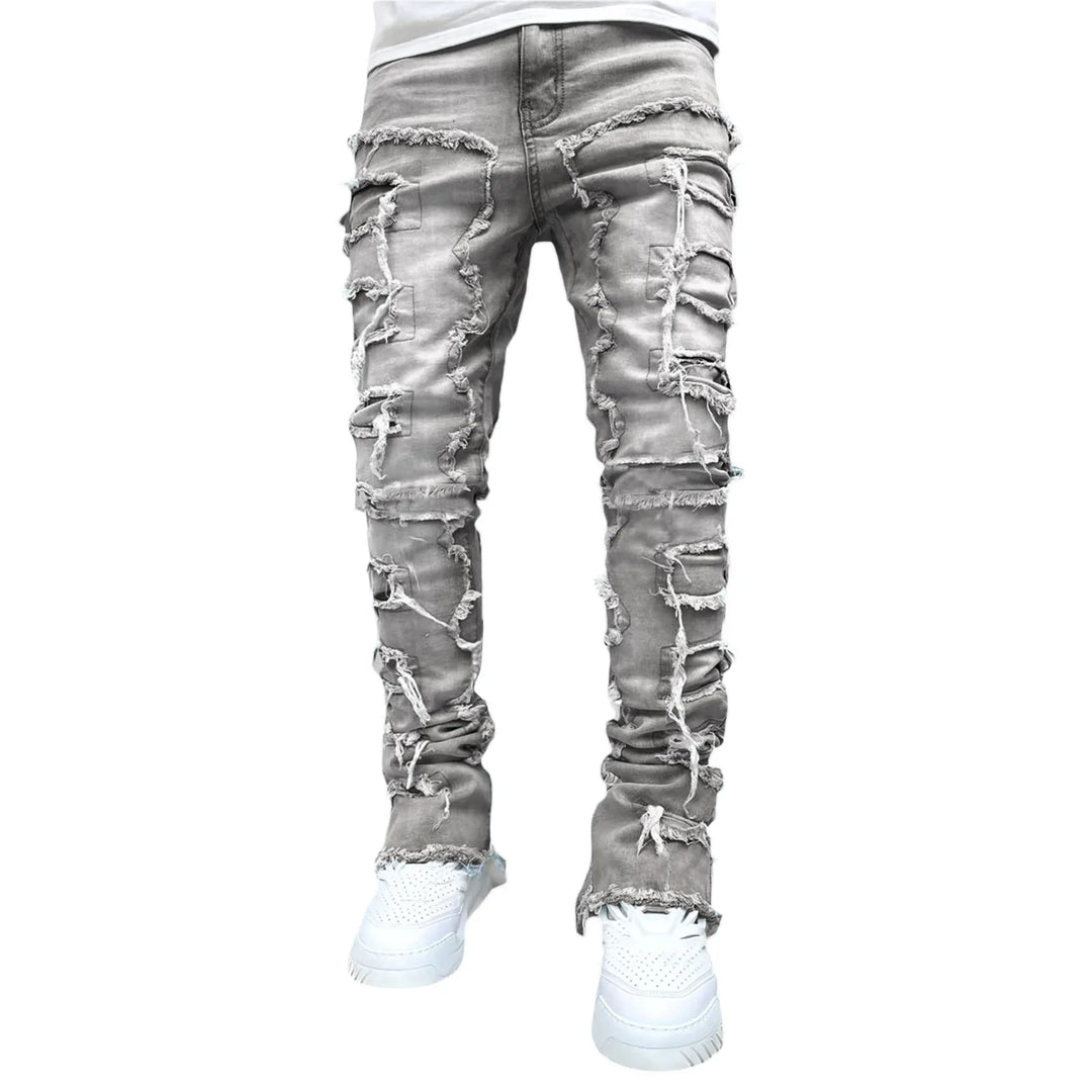 Man modeling trendy slim fit distressed ripped jeans. Edgy urban street style denim for a casual look.