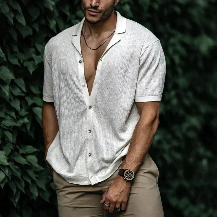 Man wearing a stylish textured Cuban collar button-down summer shirt. Ideal for men's summer fashion.