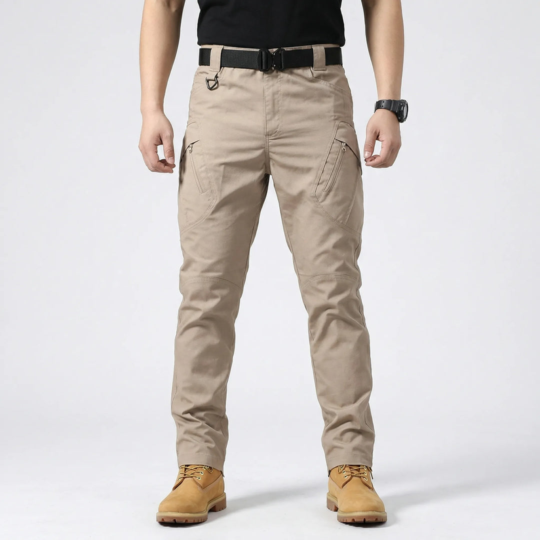 A man wears durable tactical cargo pants, ideal for outdoor activities, offering comfort & 9 utility pockets.