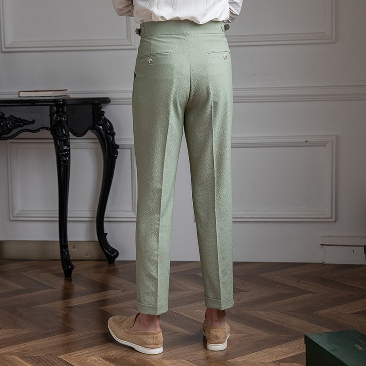 Close-up of pleats on men's tailored high-waist trousers. Modern straight leg design, smart-casual dress pants.