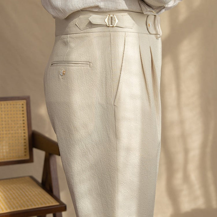 Men's tailored high-waist pleated trousers in versatile blue. Straight leg dress pants for contemporary office style.