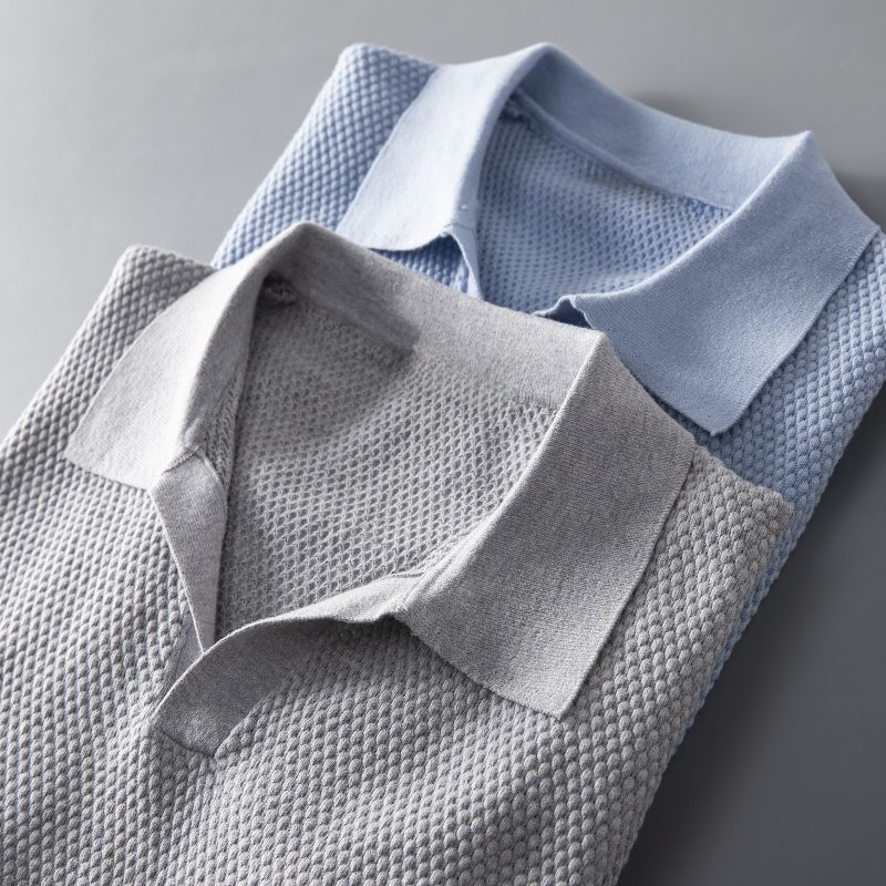 Close-up of a men's short sleeve polo, showcasing its unique textured geometric pattern.