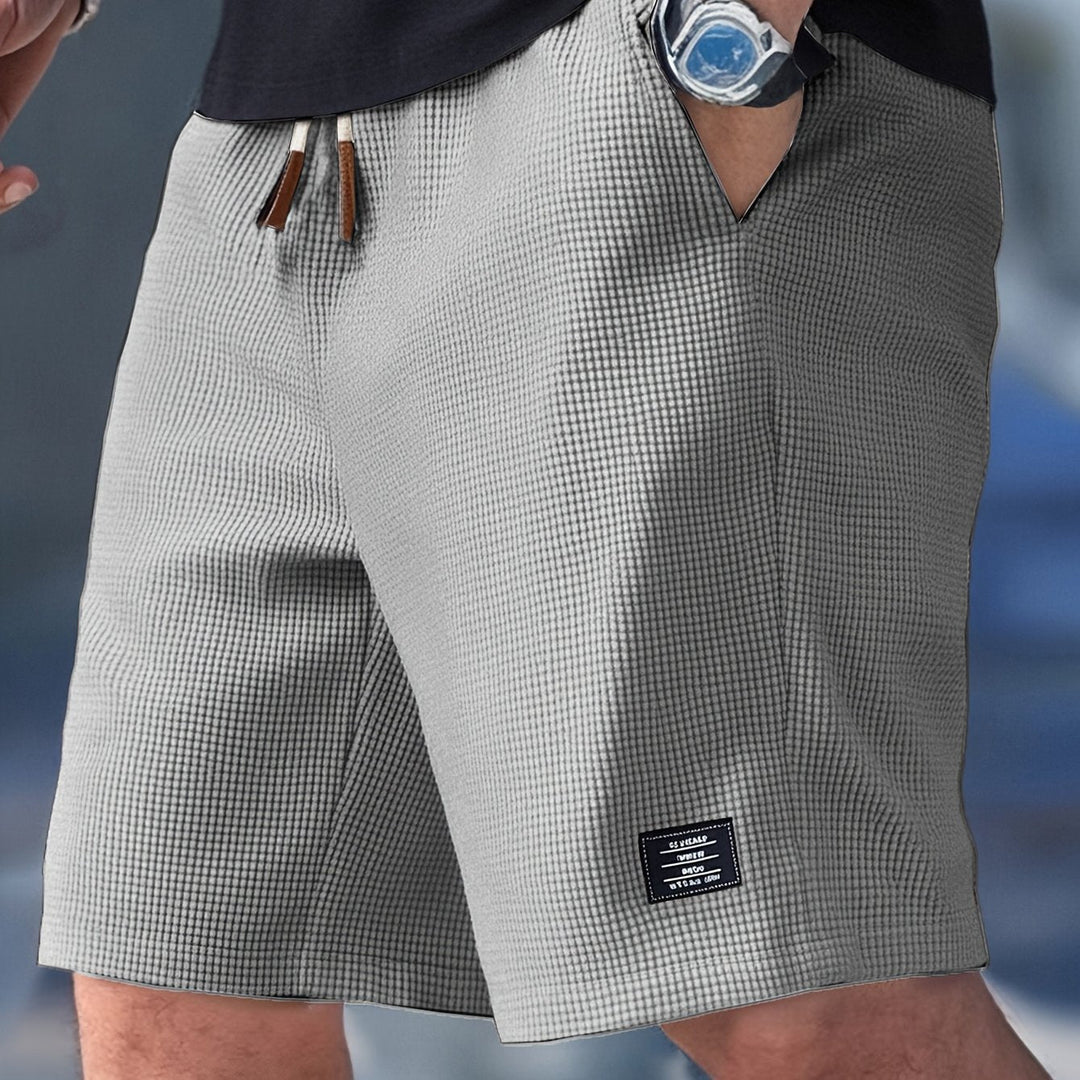 Black men's relaxed fit waffle knit shorts, versatile for casual, lounge, travel, and summer wear.