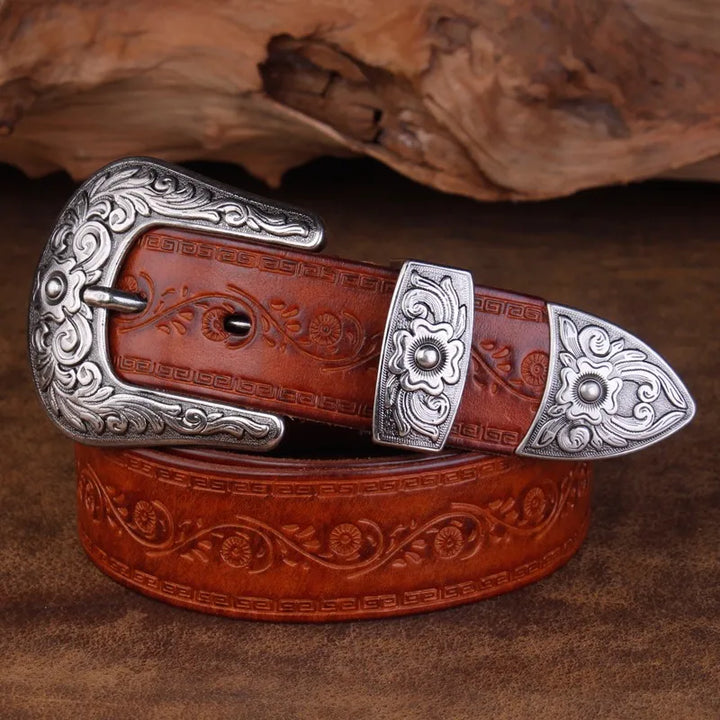 Men's coffee leather western belt, embossed with a scroll design, featuring a decorative engraved metal buckle.