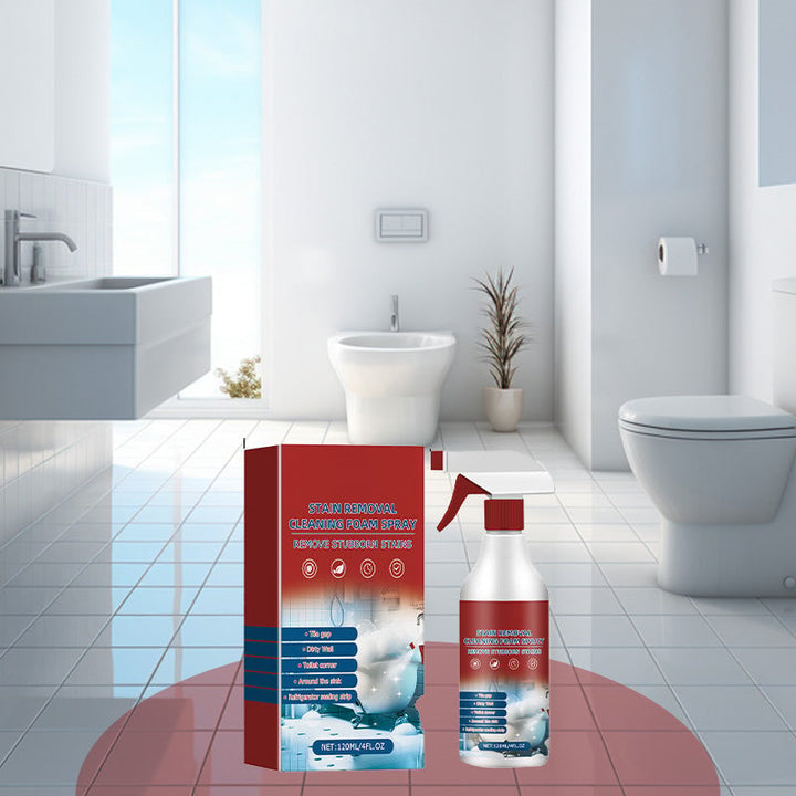 Hand holding Multisurface Stain Removal Cleaning Foam Spray bottle, aiming at a stained kitchen counter.