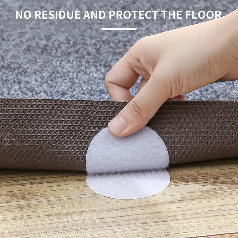 Set of four corner rug grippers, black, for stopping slippage of household carpets.