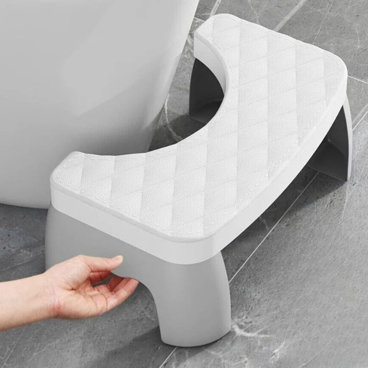 White non-slip toilet squat stool in a modern bathroom. Ergonomic design for improved posture & ultimate comfort.