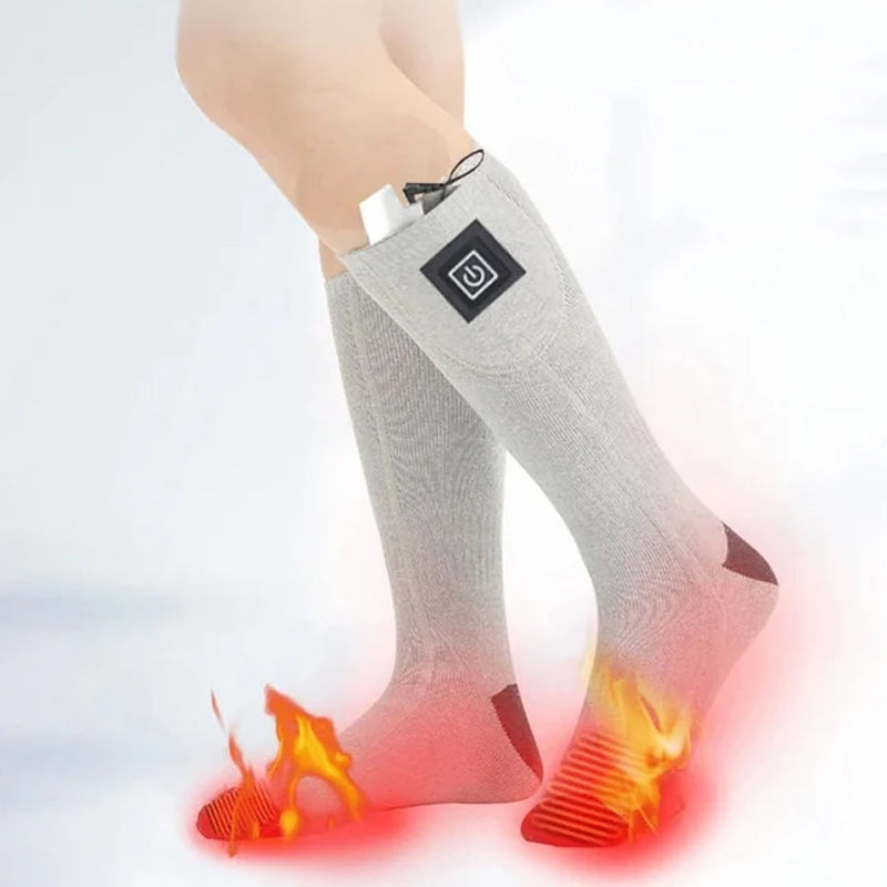 Model wearing black heated socks with ski boots, showcasing warmth for winter sports.