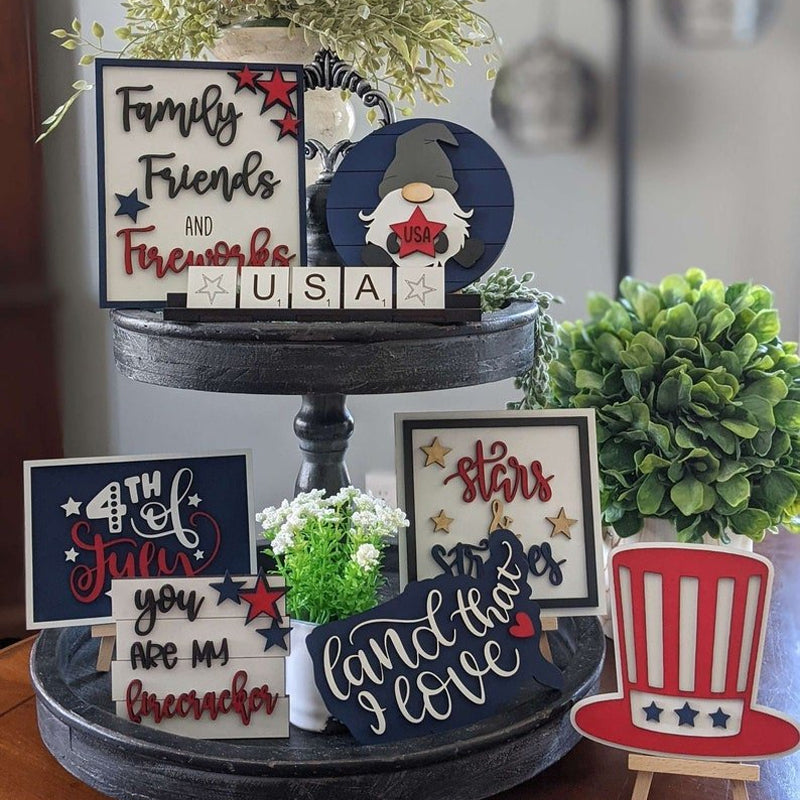 Patriotic Americana tiered tray decor set with wooden signs, stars, & banner for holiday display.