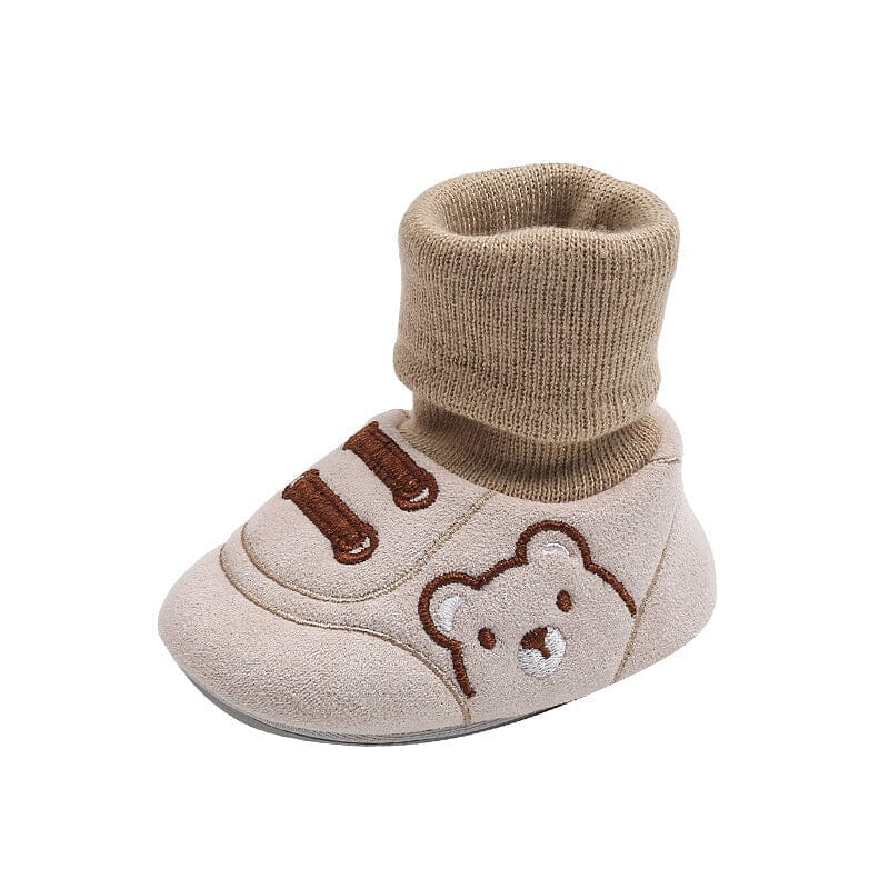 A baby's tiny toes peeking from cozy plush winter booties, soft sole