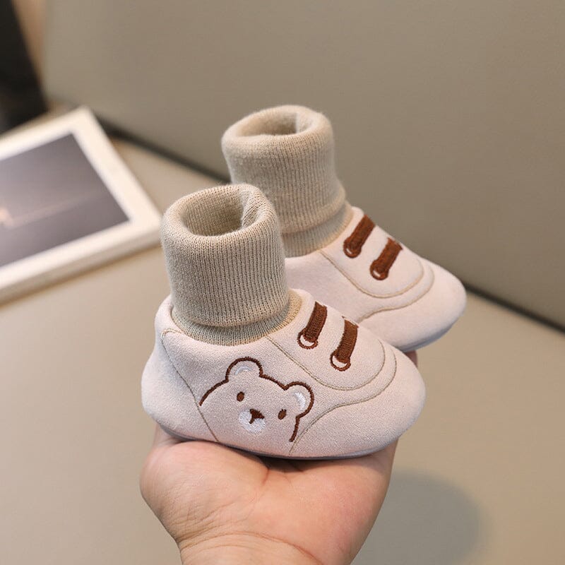 Infant asleep, wearing warm and soft plush winter booties, gentle footwear